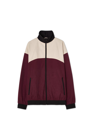 A color-blocked windbreaker jacket with a high collar, zipper closure, side pockets, elastic cuffs and hem in ecru white, black, and cherry red.