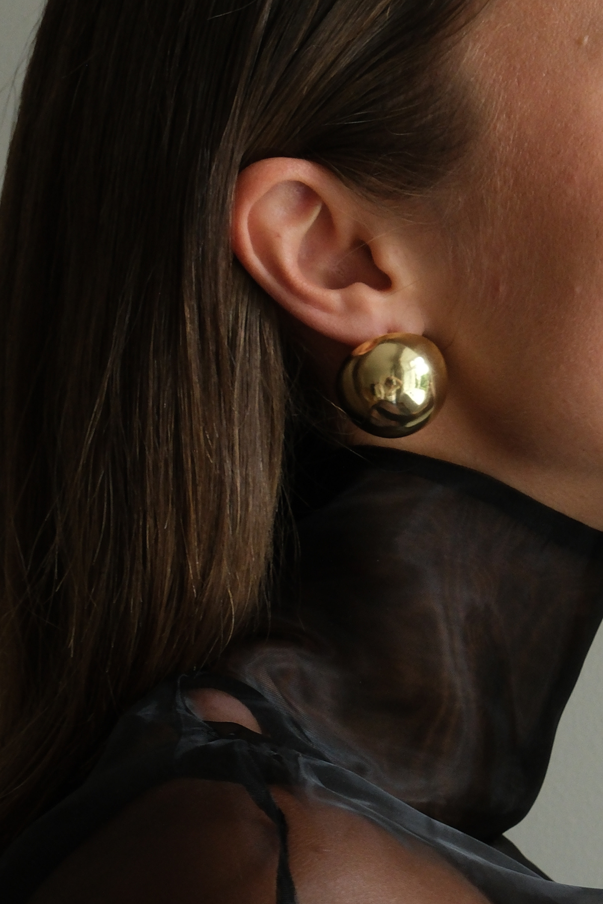 The Ball Earrings in gold, worn