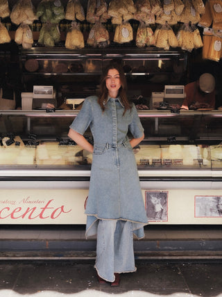 Model wearing The Asymmetric Denim Dress in front of an Italian shop