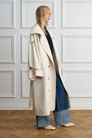 Side view of an oversized beige Lyocell trench coat with wide leg jeans