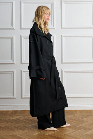 Side view of an oversized black Lyocell trench coat with belt